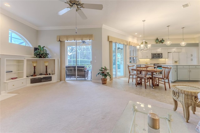 interior space featuring crown molding, a healthy amount of sunlight, and ceiling fan with notable chandelier