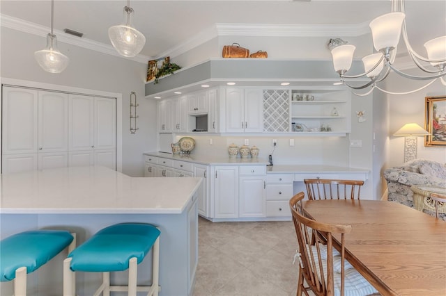 kitchen with crown molding, a notable chandelier, pendant lighting, light tile patterned floors, and white cabinetry