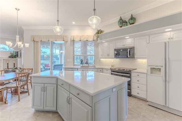 kitchen with a center island, decorative light fixtures, stainless steel appliances, and sink