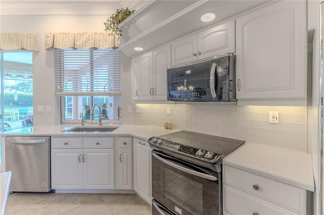 kitchen with light tile patterned floors, white cabinetry, black appliances, crown molding, and sink