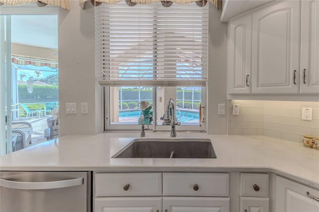 kitchen featuring sink, white cabinets, dishwasher, and backsplash