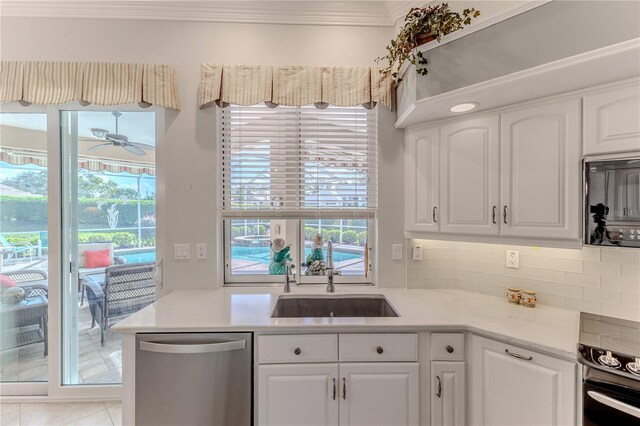 kitchen with stainless steel dishwasher, white cabinetry, and a wealth of natural light