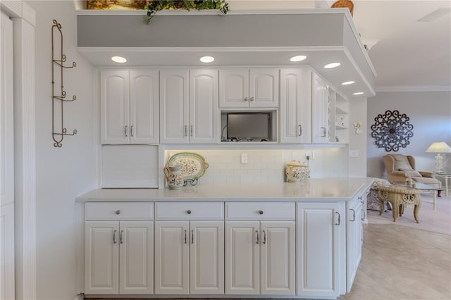 kitchen featuring crown molding, white cabinetry, backsplash, and light tile patterned floors