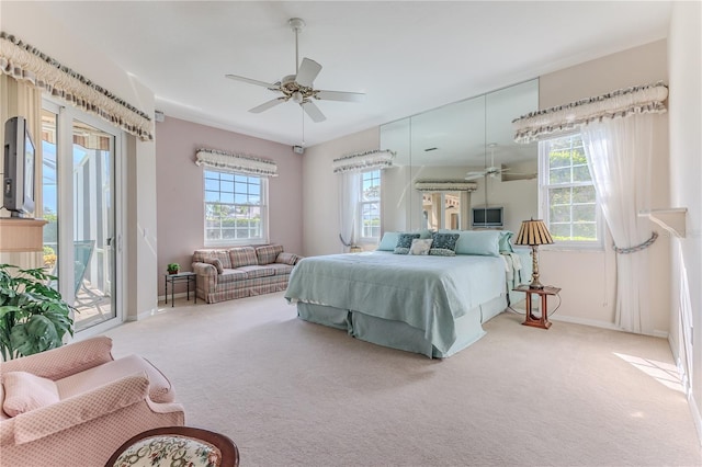 bedroom with access to outside, light colored carpet, and ceiling fan