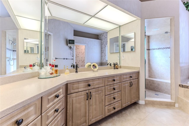 bathroom with vanity, a tile shower, and tile patterned floors