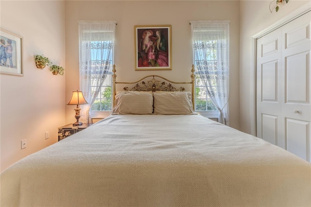 carpeted bedroom featuring multiple windows and a closet