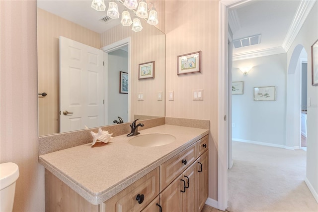 bathroom with toilet, crown molding, and vanity