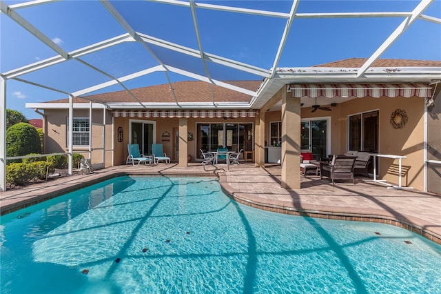 view of swimming pool with outdoor lounge area, a patio area, glass enclosure, and ceiling fan