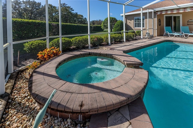 view of pool featuring an in ground hot tub, a patio, and glass enclosure