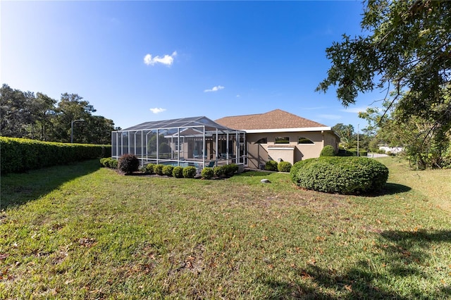 rear view of house with a lawn and a lanai