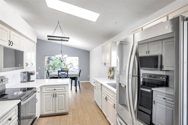 kitchen featuring stainless steel appliances, vaulted ceiling with skylight, decorative light fixtures, and white cabinets