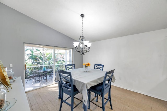 dining area featuring an inviting chandelier, lofted ceiling, and light wood-type flooring