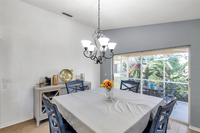 dining room with light hardwood / wood-style floors, an inviting chandelier, and plenty of natural light