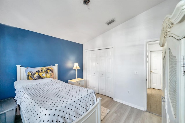 bedroom featuring a closet, vaulted ceiling, and light hardwood / wood-style flooring