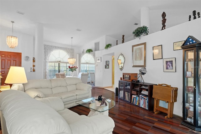 living room with vaulted ceiling, an inviting chandelier, and dark hardwood / wood-style floors