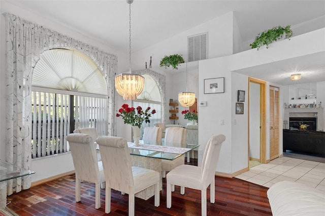 dining space featuring wood-type flooring and vaulted ceiling