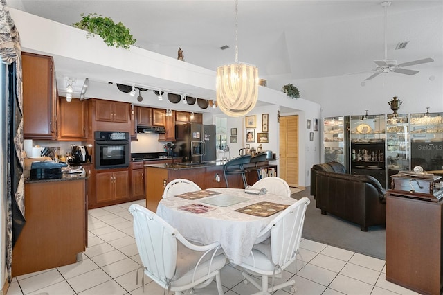 kitchen with a kitchen island, stainless steel fridge with ice dispenser, black oven, and light tile patterned flooring