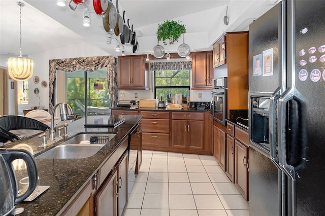 kitchen featuring lofted ceiling, light tile patterned floors, black appliances, sink, and decorative light fixtures