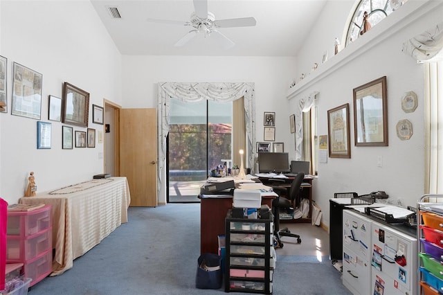 carpeted office space featuring ceiling fan