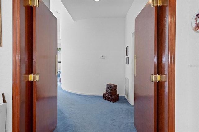 hall with dark colored carpet