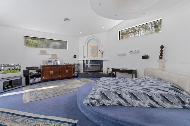 bedroom featuring a premium fireplace, multiple windows, and carpet