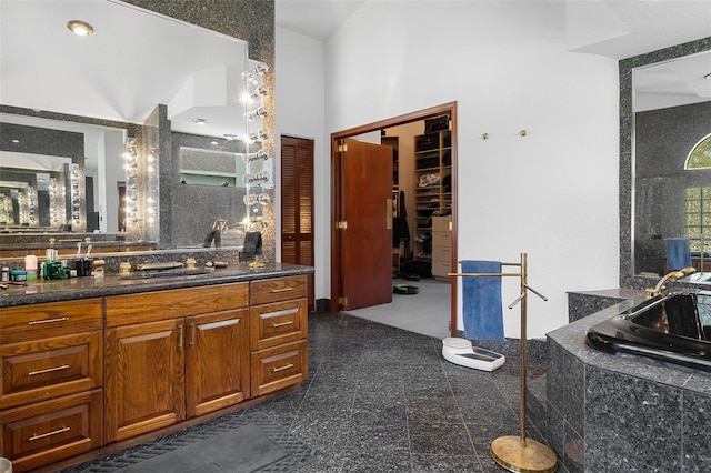 bathroom featuring vanity and tiled bath