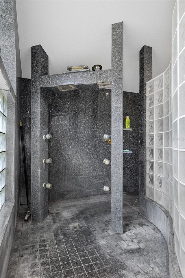 bathroom featuring tile walls and a tile shower