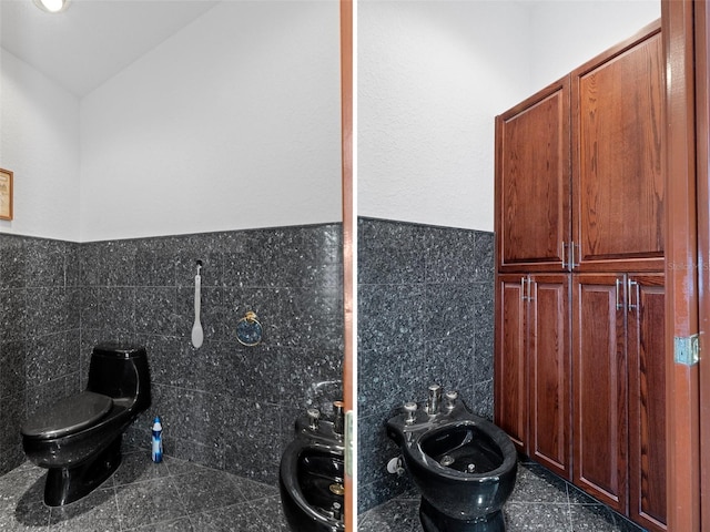 bathroom featuring toilet, vaulted ceiling, a bidet, and backsplash