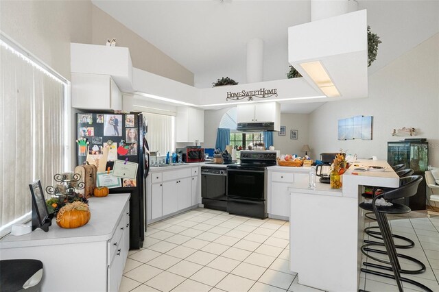 kitchen with white cabinetry, black appliances, kitchen peninsula, and a kitchen bar