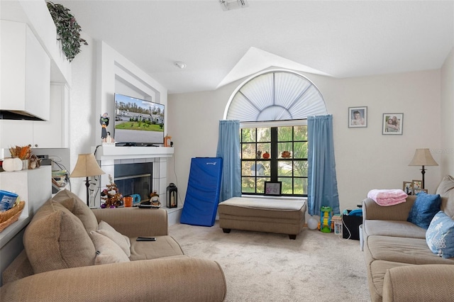 living room featuring light carpet and a tiled fireplace