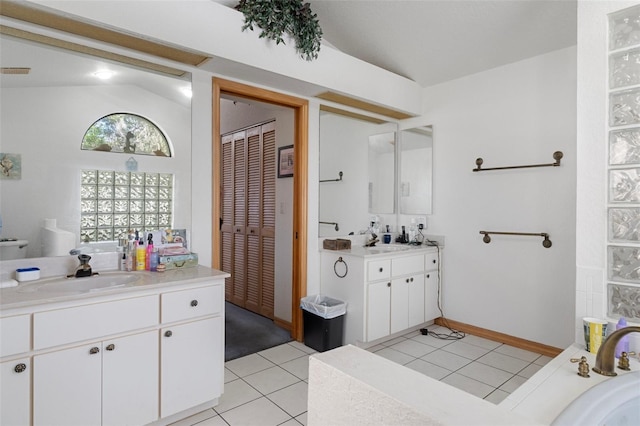 bathroom with vanity, lofted ceiling, and tile patterned floors