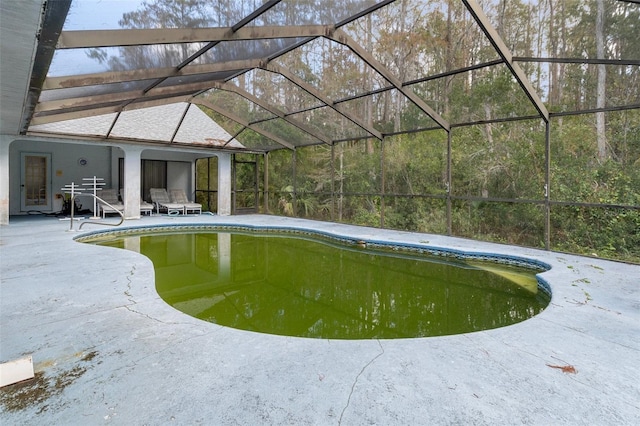 view of swimming pool with a patio area and glass enclosure