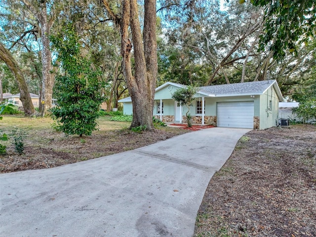 ranch-style home with cooling unit and a garage