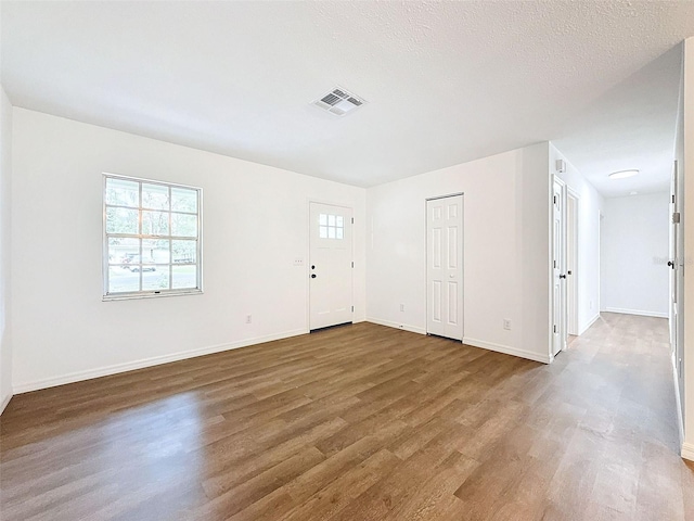 spare room with a textured ceiling and wood-type flooring