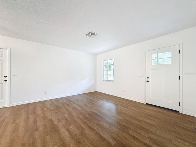 entrance foyer with a healthy amount of sunlight, a textured ceiling, and dark hardwood / wood-style floors