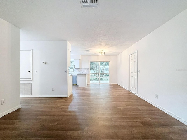 unfurnished living room with a textured ceiling and dark hardwood / wood-style flooring