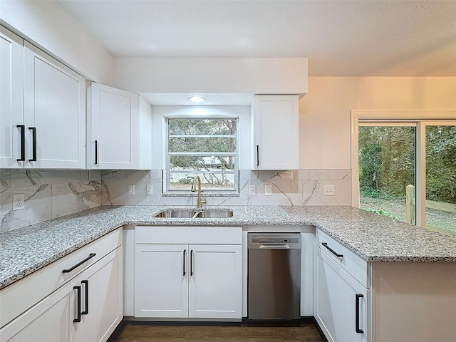 kitchen with a wealth of natural light, white cabinetry, and light stone counters