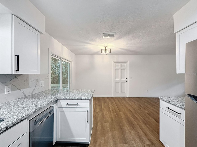 kitchen with appliances with stainless steel finishes, white cabinets, light stone counters, and light wood-type flooring