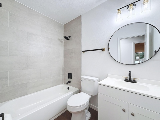 full bathroom with toilet, tiled shower / bath, a textured ceiling, and vanity