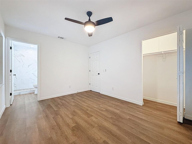 unfurnished bedroom with a closet, ceiling fan, connected bathroom, and light wood-type flooring