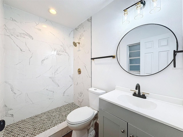 bathroom featuring vanity, tiled shower, a textured ceiling, and toilet