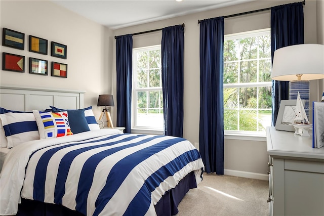 bedroom with light carpet and multiple windows