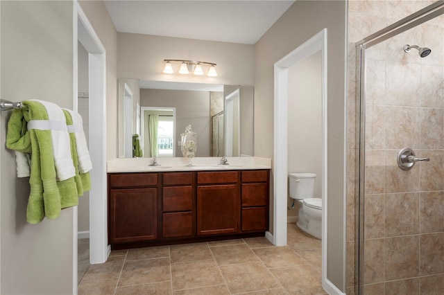 bathroom featuring toilet, walk in shower, vanity, and tile patterned floors