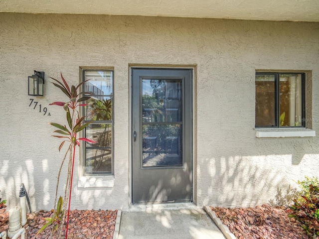 doorway to property with stucco siding