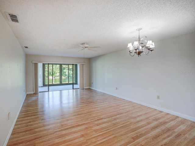 empty room featuring light hardwood / wood-style flooring, a textured ceiling, and ceiling fan with notable chandelier