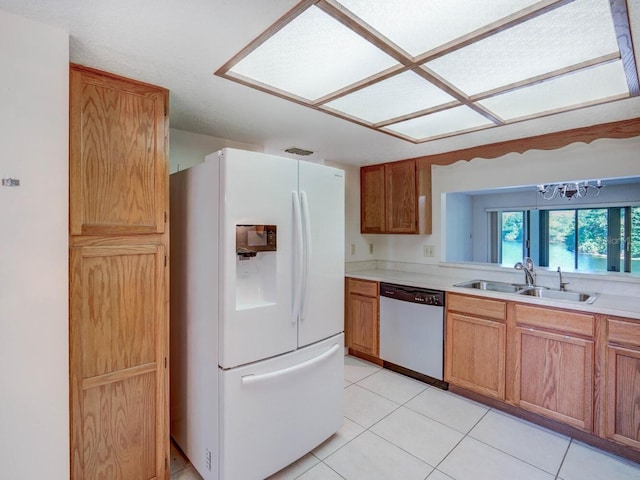 kitchen with stainless steel dishwasher, sink, light tile patterned flooring, and white refrigerator with ice dispenser