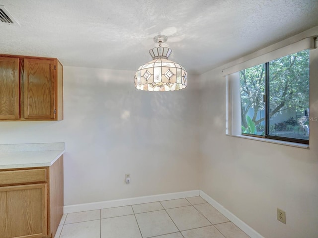 7719 Cosme Dr Unit 1, Hudson, FL 34667 - unfurnished dining area featuring baseboards, light tile patterned flooring, and a textured ceiling