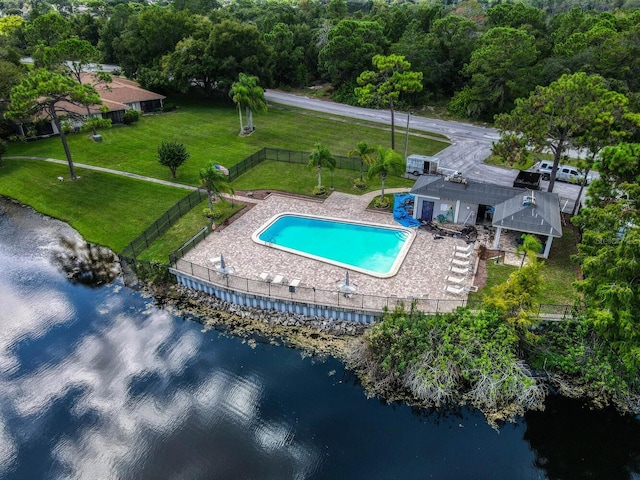 view of swimming pool with a water view, a patio area, and a lawn