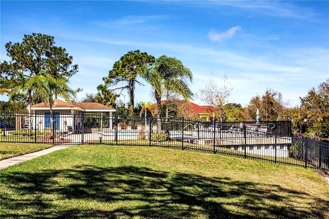 view of property's community featuring a swimming pool and a lawn