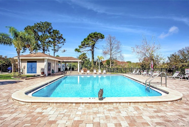 pool with a patio and fence